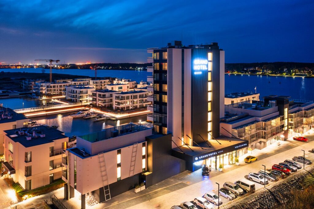 a hotel with a lot of cars parked on the water